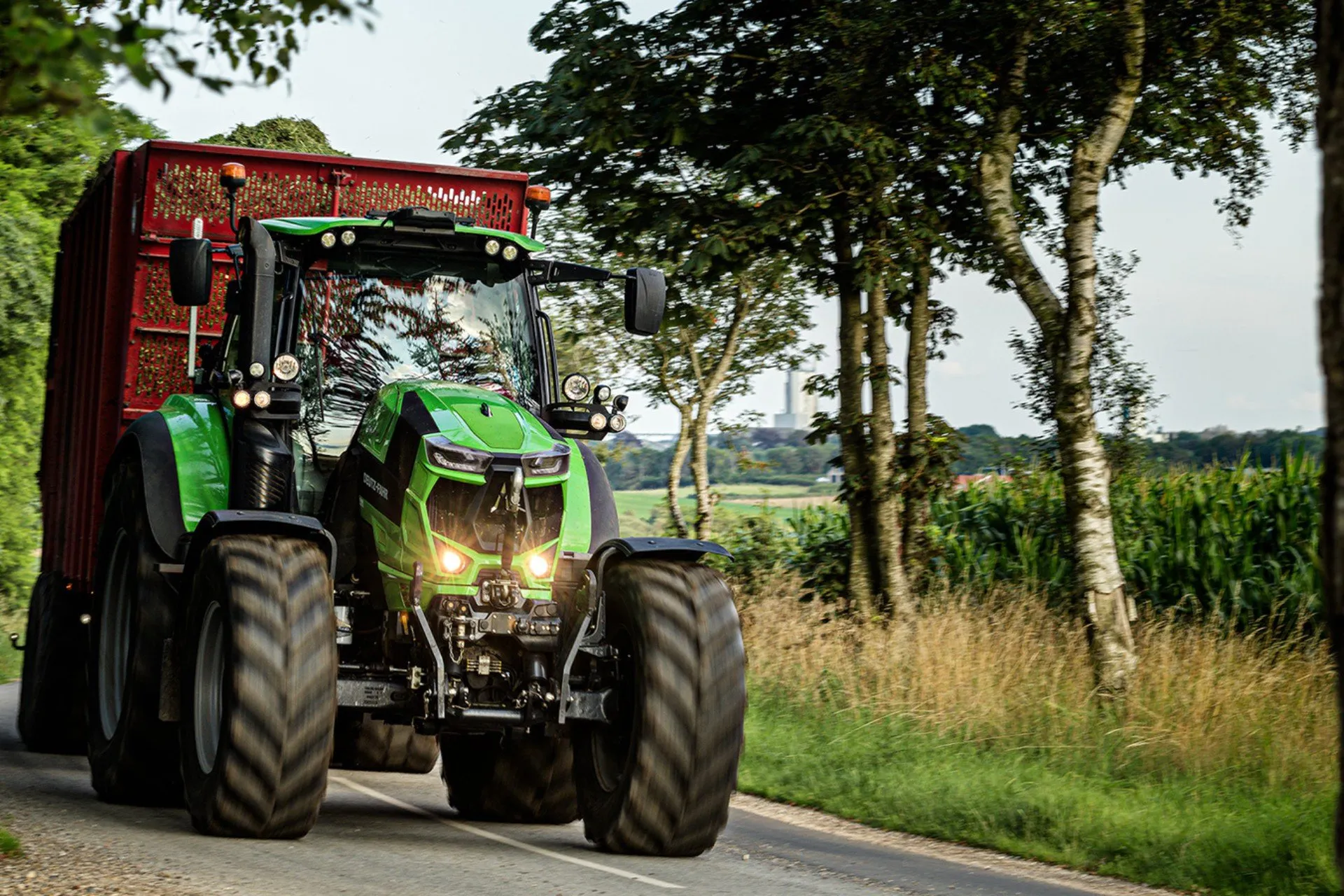 Deutz-Fahr-traktor med vagn på en landsväg